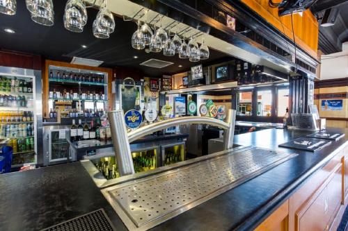 a bar with a sink and a counter with alcohol at Newcastle Hotel in Newcastle