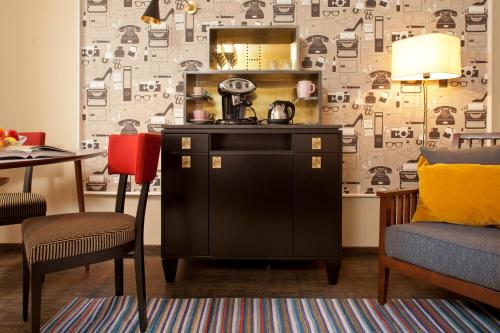a kitchen with a counter and a chair and a table at Henri Hotel Hamburg Downtown in Hamburg