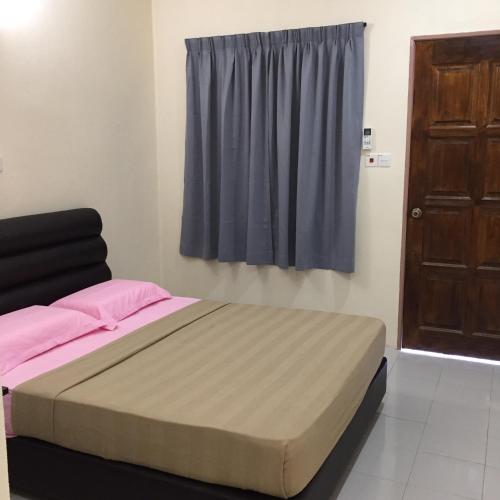 a bed in a room with a window and a door at Samudra Beach Chalet in Perhentian Island