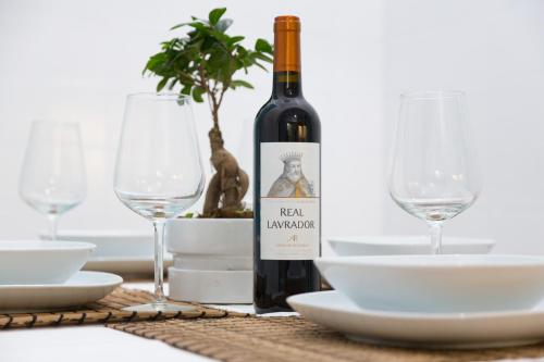 a bottle of wine sitting on a table with glasses at C&O Guest House Lisbon in Lisbon
