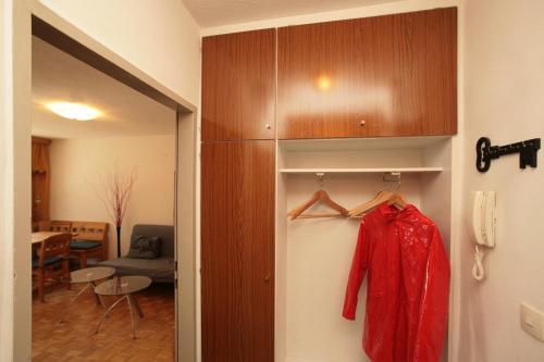 une veste rouge suspendue sur un mur dans une pièce dans l'établissement Appartement René, à Zell am See
