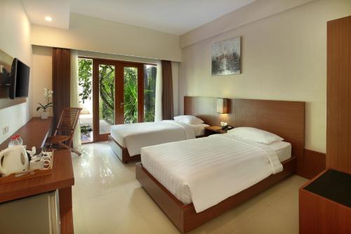 A bed or beds in a room at Bali Chaya Hotel Legian