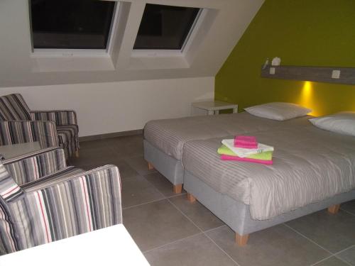 a hotel room with two beds and a chair at Logies Ternier in Nieuwpoort