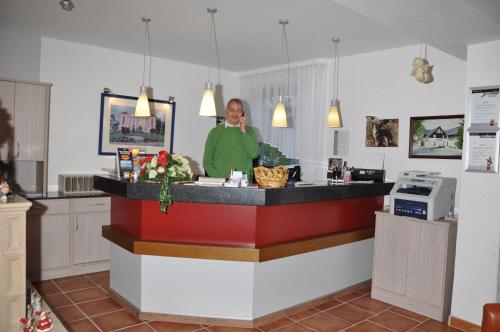 a woman standing behind a counter in a kitchen at Landhaus Dürkop in Wolfenbüttel