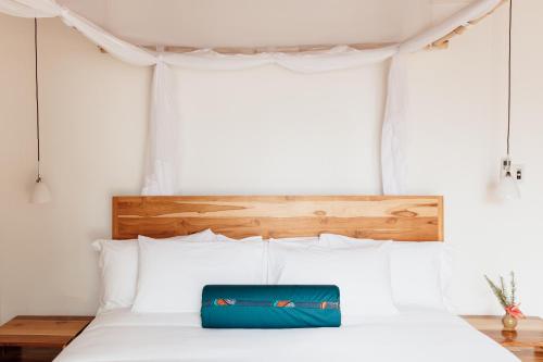 a bed with a blue bag sitting on top of it at Hemingways Retreat Kigali in Kigali