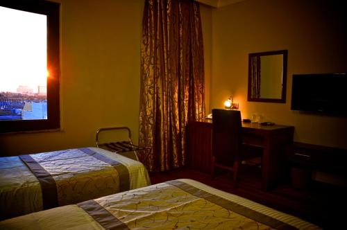 埃爾比勒的住宿－埃爾比勒BL酒店，酒店客房设有两张床、一张书桌和一个窗户。