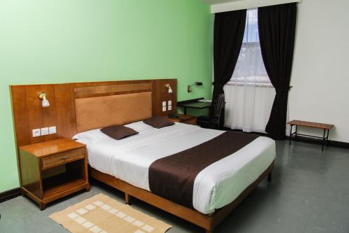 a bedroom with a large bed and a window at Motel d'Antananarivo in Antananarivo