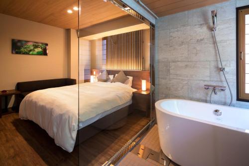 a bedroom with a bed and a bath tub at Hotel Miyajima Villa in Miyajima