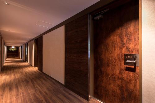 an empty corridor with a wall of wood paneling at Hotel Miyajima Villa in Miyajima