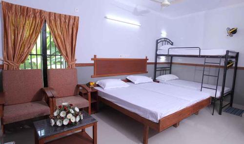 a bedroom with two bunk beds and a chair at The Boat Jetty Bungalow in Cochin