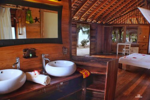 a bathroom with two sinks and a mirror at Anjiamarango Beach Resort in Nosy Be