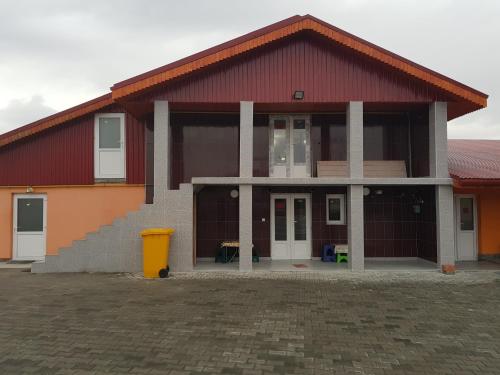 una casa con techo rojo y un cubo de basura amarillo en Hanul Lui Ionut en Satu Mare