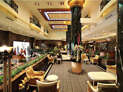 a lobby of a hotel with tables and chairs at Merdeka Palace Hotel & Suites in Kuching