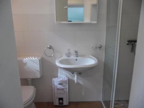a white bathroom with a sink and a toilet at Ferienwohnung Prälank in Neustrelitz
