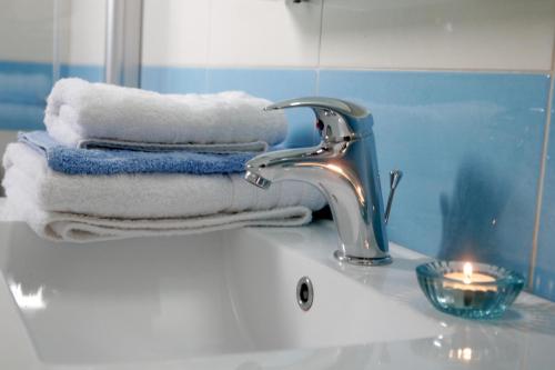 a bathroom sink with towels and a faucet at Boutique Hotel Iasmos in Trizonía