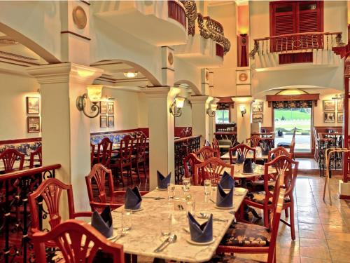 
a restaurant with tables and chairs in it at Merdeka Palace Hotel & Suites in Kuching
