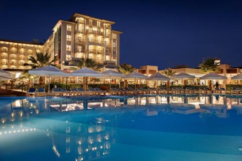een zwembad voor een hotel 's nachts bij Sunis Elita Beach Resort Hotel & SPA in Kizilagac