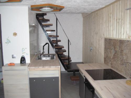 a kitchen with a sink and a spiral staircase at Ferienhaus-Cerny in Bad Goisern