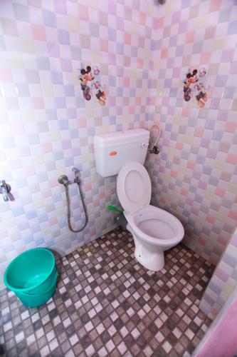 a pink and white bathroom with a toilet and a shower at Pleasant Inn in Cochin