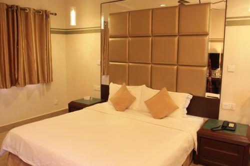 a bedroom with a large white bed with two tables at Beringgis Beach Resort & Spa in Papar
