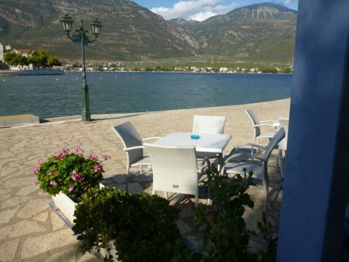 a table and chairs on the beach with the water at Boutique Hotel Iasmos in Trizonía