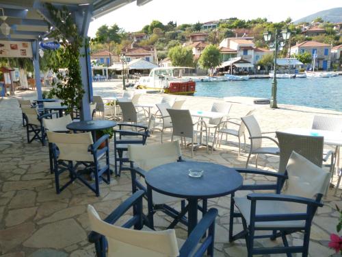 a group of tables and chairs next to the water at Boutique Hotel Iasmos in Trizonía
