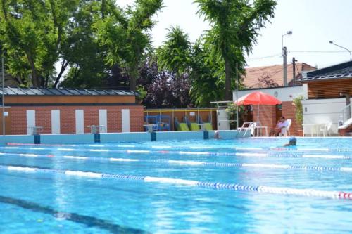 a large swimming pool with blue water at CVSE Clubház és Panzió in Cegléd