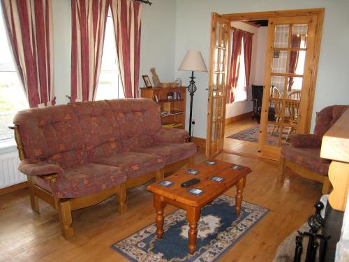 a living room with a couch and a coffee table at Holiday Home Glenvale Cottage by Interhome in Valley