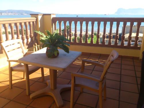 a table with two chairs and a plant on a balcony at Hotel Mirador in Algeciras