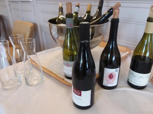 four bottles of wine on a table with glasses at Hostellerie d'Héloïse Logis in Cluny