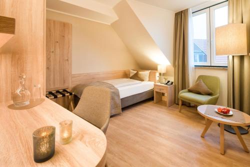 ein Hotelzimmer mit einem Bett und einem Tisch in der Unterkunft Hotel Altes Zollhaus in Horumersiel