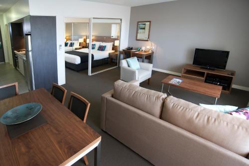 a living room with a couch and a dining room at Quest Dubbo in Dubbo