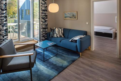 a living room with a blue couch and a table at Haus am Deich Ferienwohnungen in Prerow