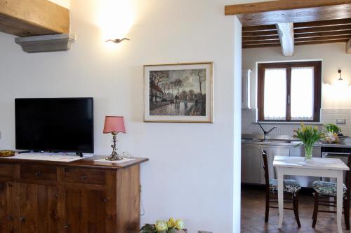 a living room with a tv and a kitchen with a table at L'Antico Cipresso in Poppi