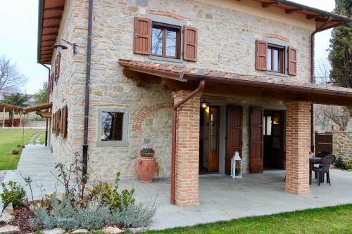 a stone house with a patio in front of it at L'Antico Cipresso in Poppi
