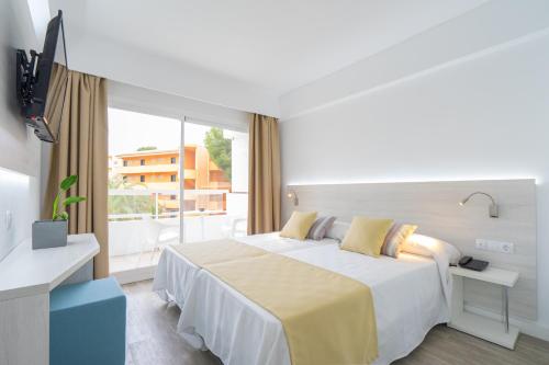 a hotel room with a bed and a large window at Bellevue Vistanova in Magaluf