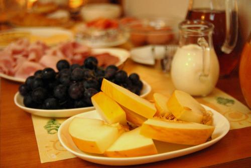 a table with plates of food with fruit and milk at Hotel Wolf in Prague