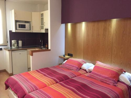 1 dormitorio con 1 cama grande con sábanas a rayas en Alojamientos Maramar, en Candás