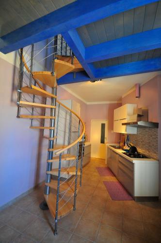 a spiral staircase in the middle of a kitchen at Blue House in Alghero