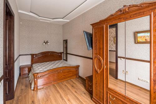 sypialnia z drewnianym łóżkiem i oknem w obiekcie Аpartments on the square of Danylo Halytskyi w Lwowie