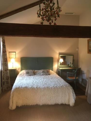 sypialnia z dużym łóżkiem i biurkiem w obiekcie Le Mas Bresson w Perpignanie