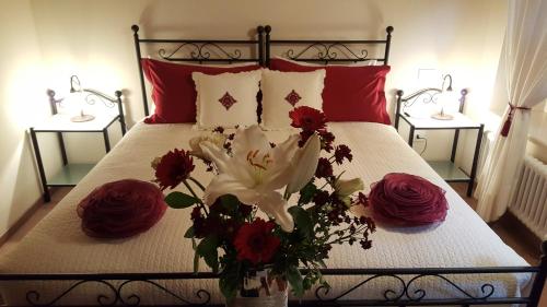 a bedroom with a bed with red and white flowers on it at Affittacamere Valnascosta in Faedis