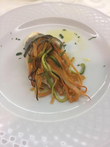 a white plate with a sandwich with vegetables on it at Hotel San Nicola in Lagonegro