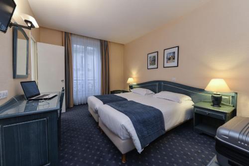 a hotel room with a large bed and a desk at Hotel du Pré in Paris