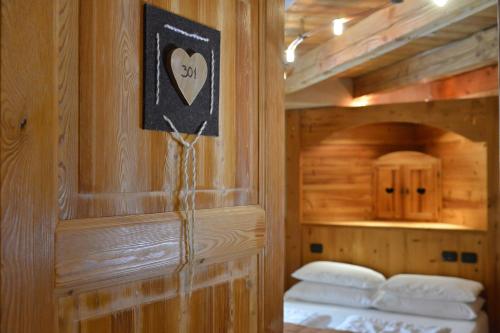 Habitación con 2 camas y un signo cardiaco en la pared. en Hotel Miravidi a Cervinia, en Breuil-Cervinia