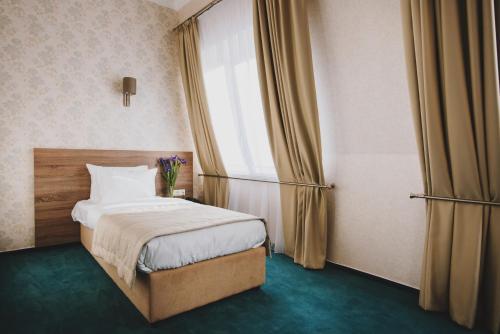 a hotel room with a bed and a window at Hotel Alkor in Truskavets