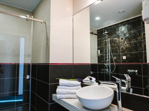 a bathroom with a sink and a shower at Hotel Alkor in Truskavets