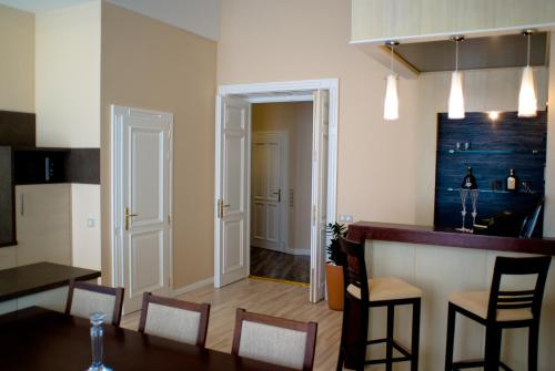 a kitchen and dining room with a table and chairs at Soleil Apartman Szeged in Szeged