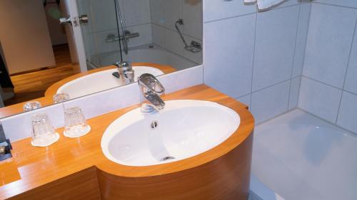 a bathroom with a sink and a bath tub at Fletcher Resort-Hotel Zutphen in Zutphen