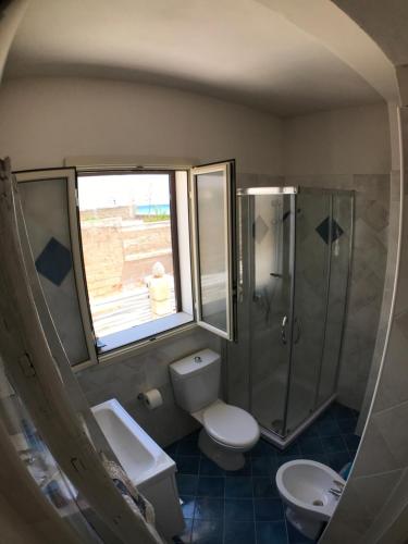 uma casa de banho com um chuveiro, um WC e um lavatório. em Appartamento sul mare em Noto Marina